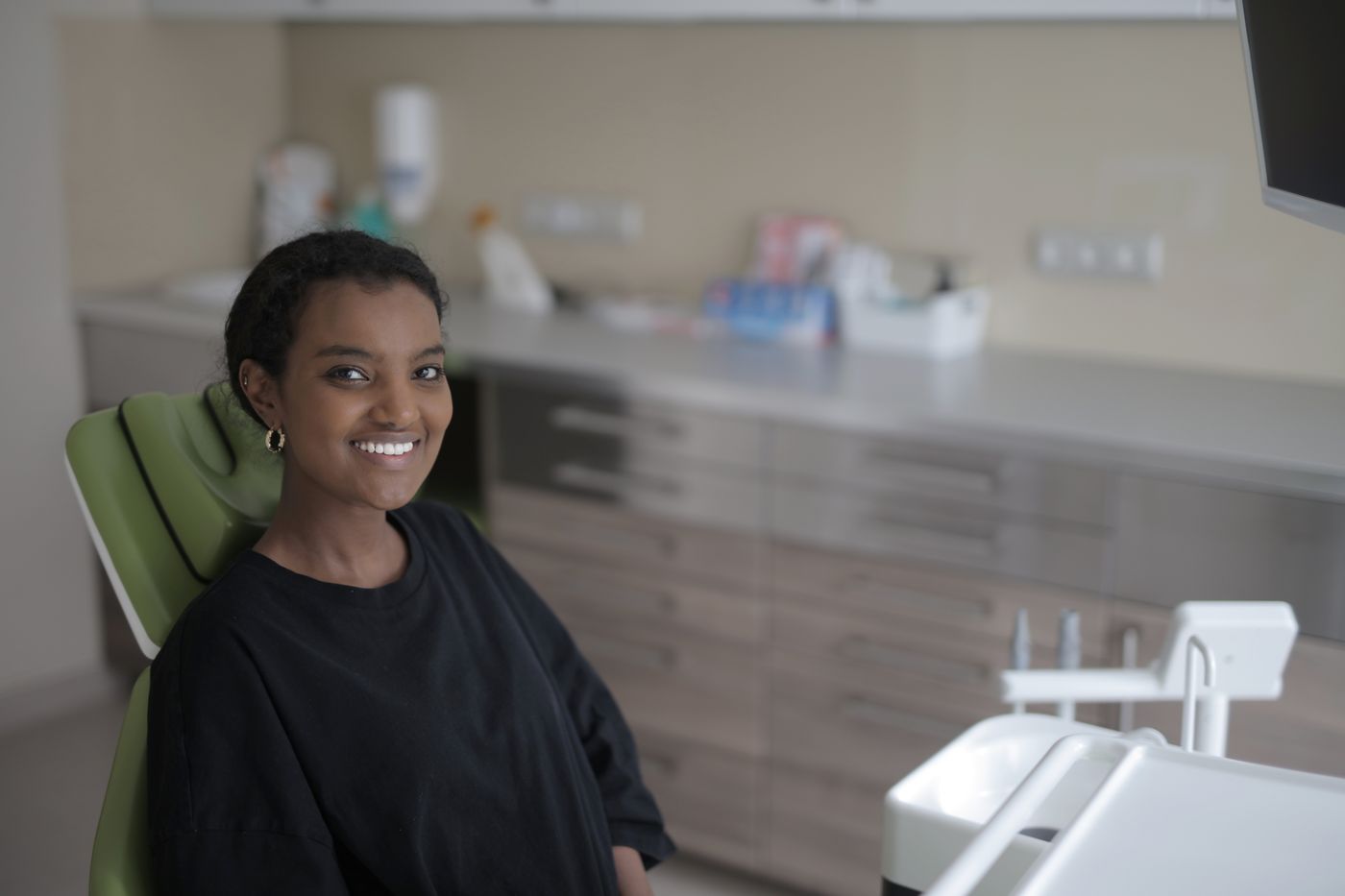 A smiling patient sitting in a dental chair
